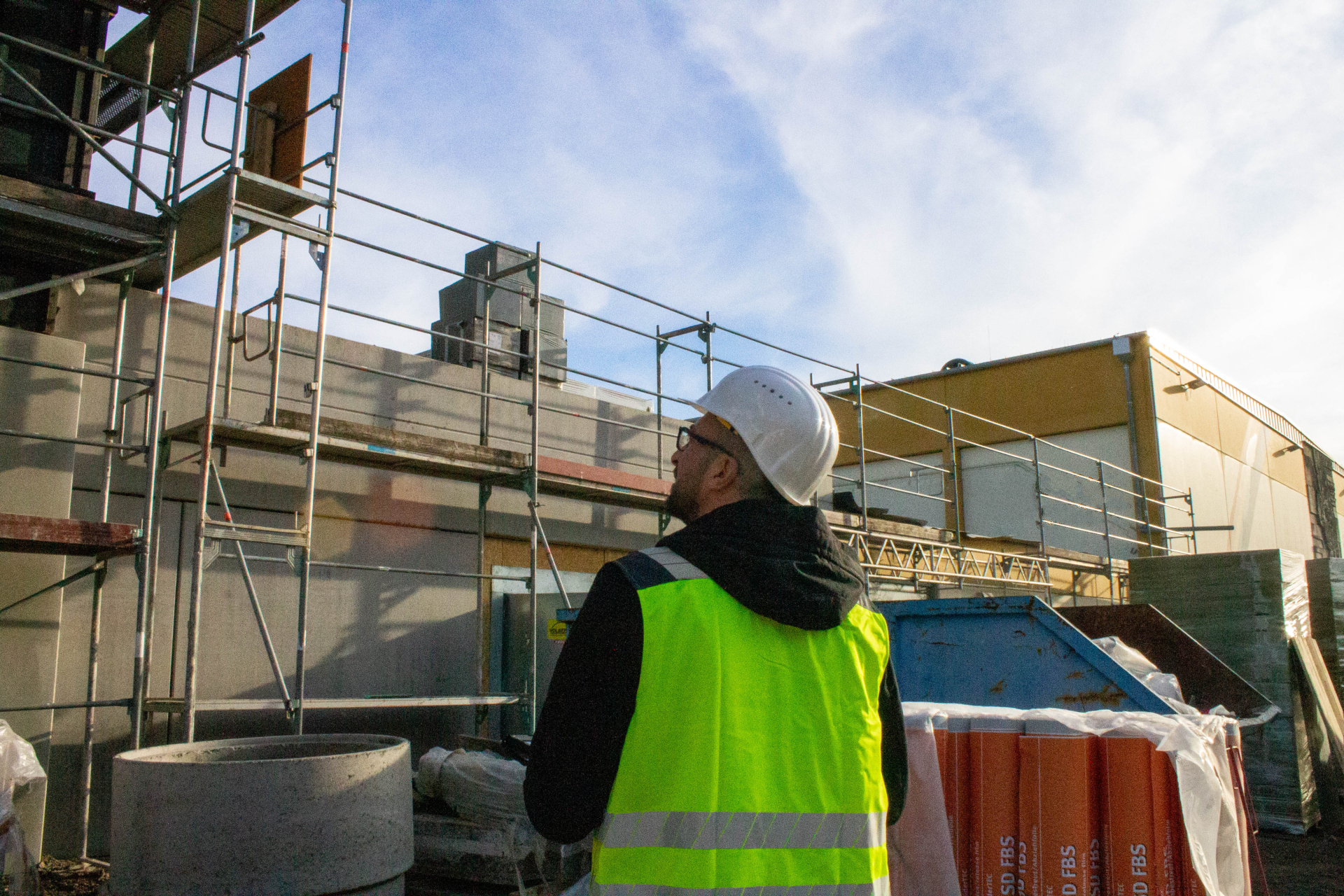 Bild von Sedin Delić, welcher nach oben auf ein Baugerüst schaut.